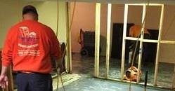 Water Damage Restoration Technicians Cleaning Carpet After A Flood